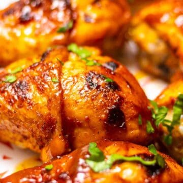 close-up of chicken drumsticks on white dish