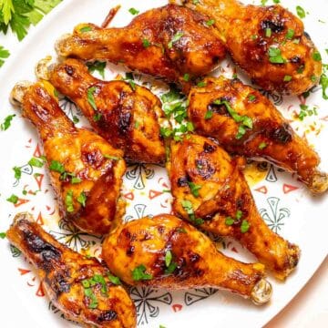 Cooked drumsticks on a plate with fresh parsley
