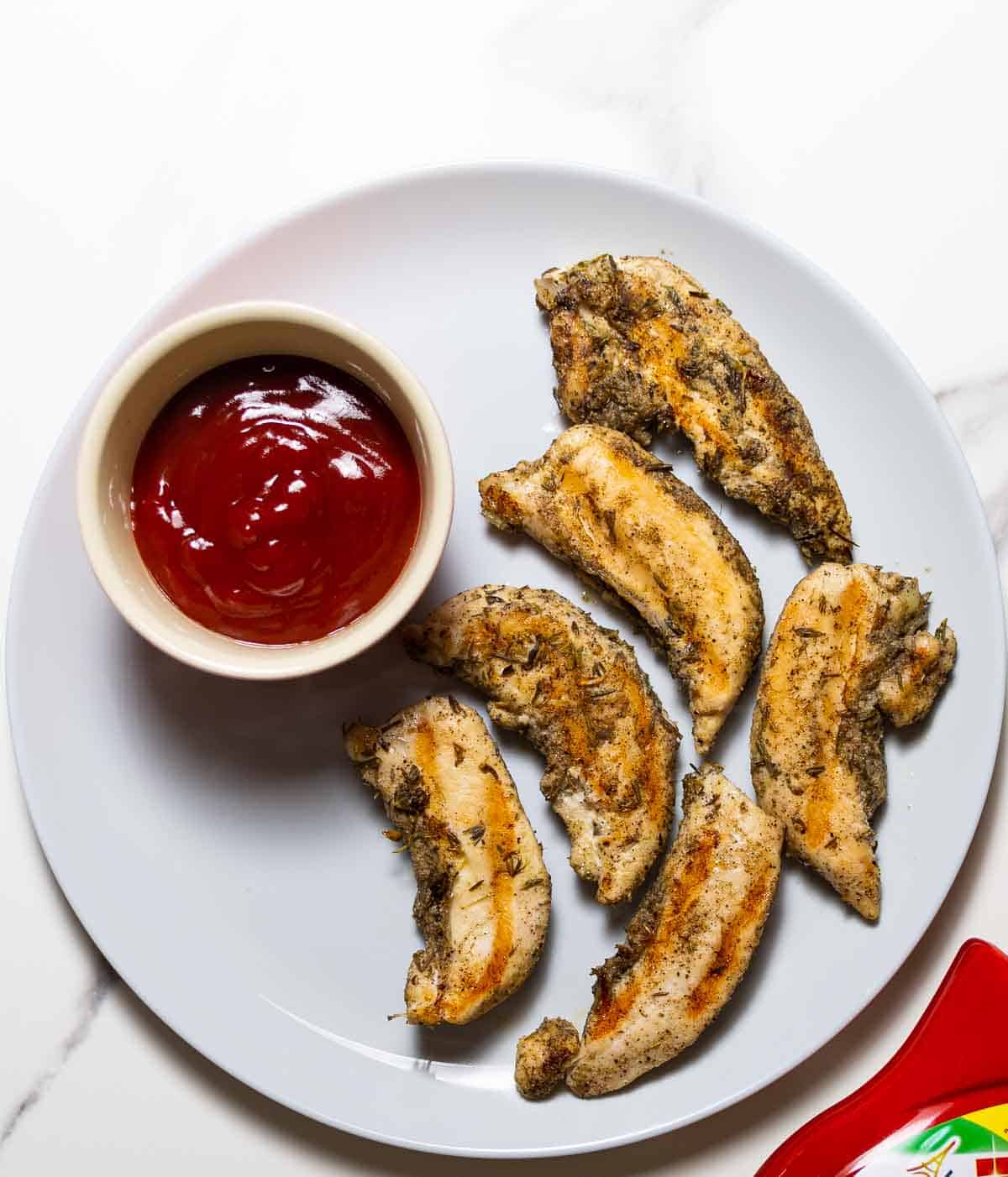 instant pot chicken tenders on gray dish next to ketchup sauce