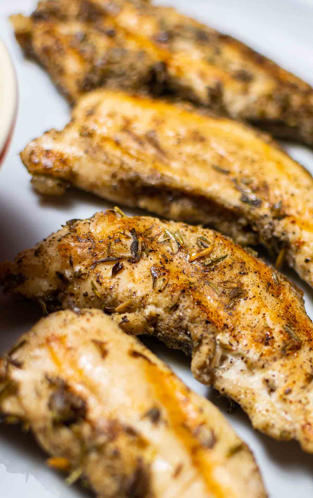 close-up of instant pot chicken tenders in white dish