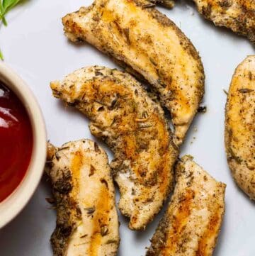 instant pot chicken tenders on gray dish next to ketchup sauce and parsley