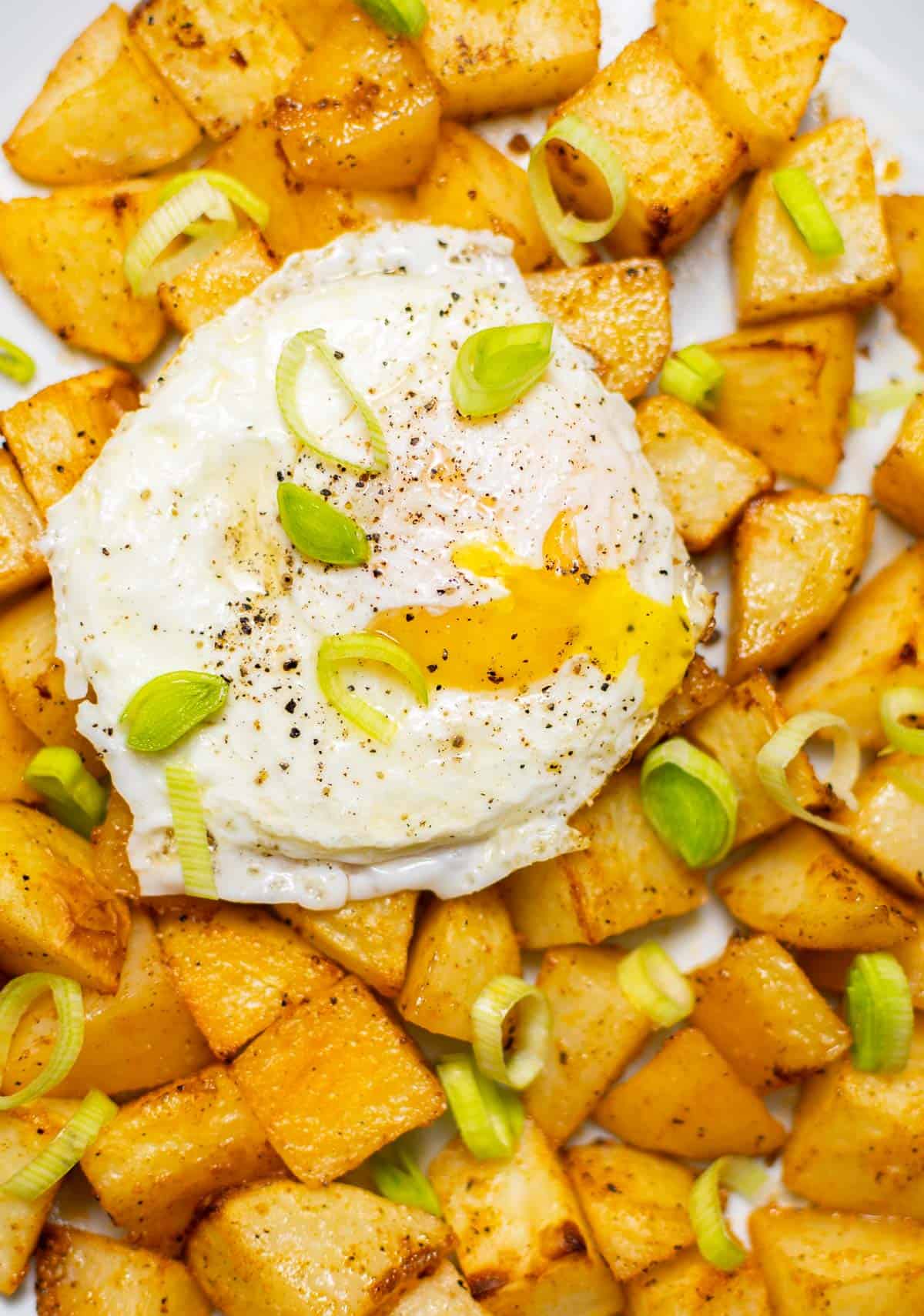 air fryer breakfast potatoes with an egg on top and leeks