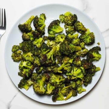 air fried broccoli florets in a grey dish on a white surface
