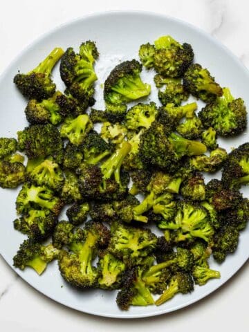 air fried broccoli florets in a grey dish on a white surface