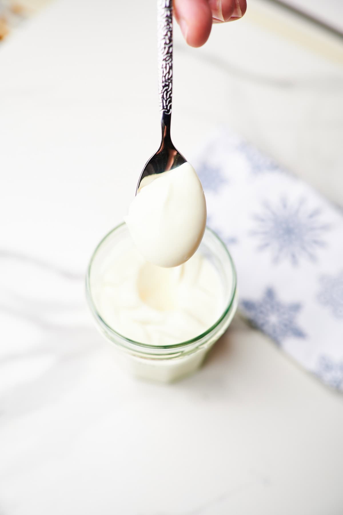 homemade mayonnaise in a glass jar with en egg in the background
