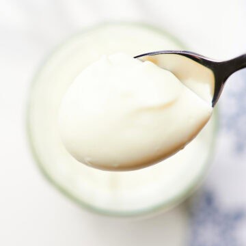 close-up homemade mayonnaise in a glass jar with en egg in background