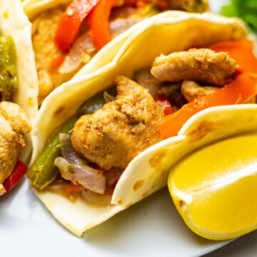 close-up of chicken fajitas with a slice of lemon on the side