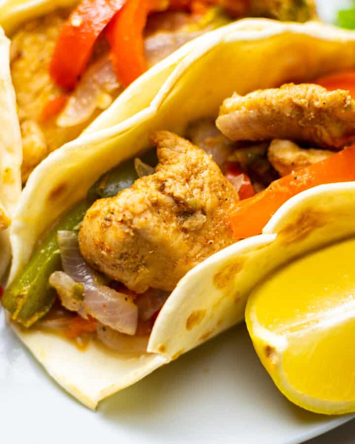 close-up of chicken fajitas with a slice of lemon on the side