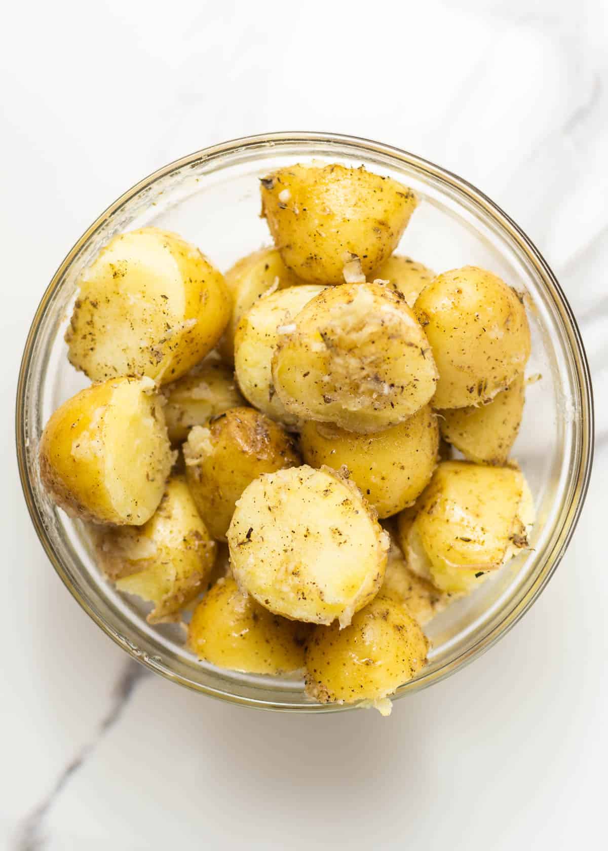 potatoes seasoned in glass bowl.