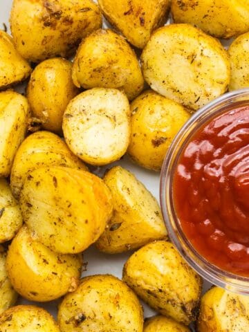 roasted yukon gold potatoes with ketchup on a grey dish