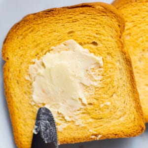 close-up of a toasted bread with butter and a knife