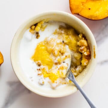 air fryer peach cobbler in a ramequin with slices of peach on the side