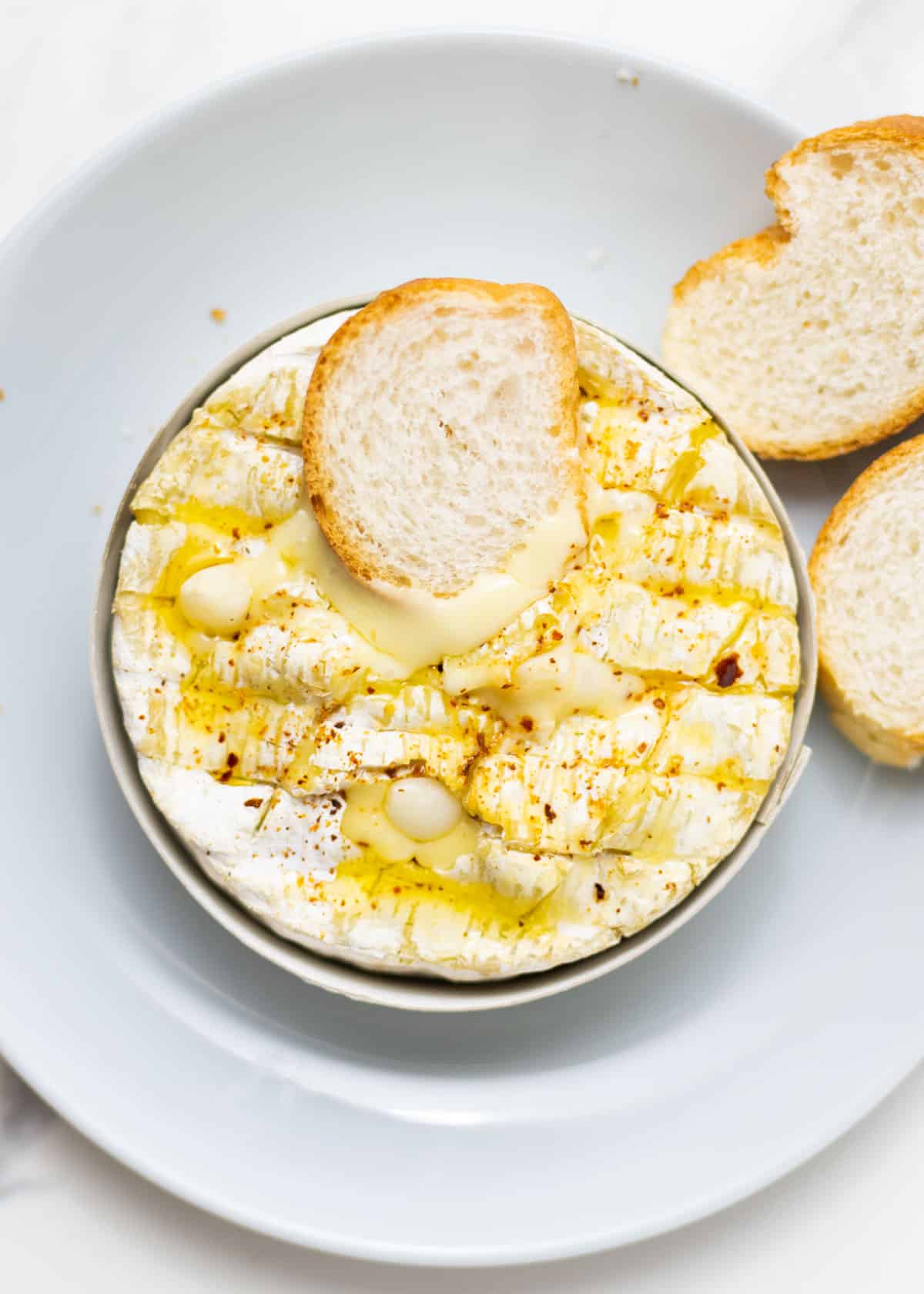 overlay shot of an air fryer baked camembert with bread slices on top