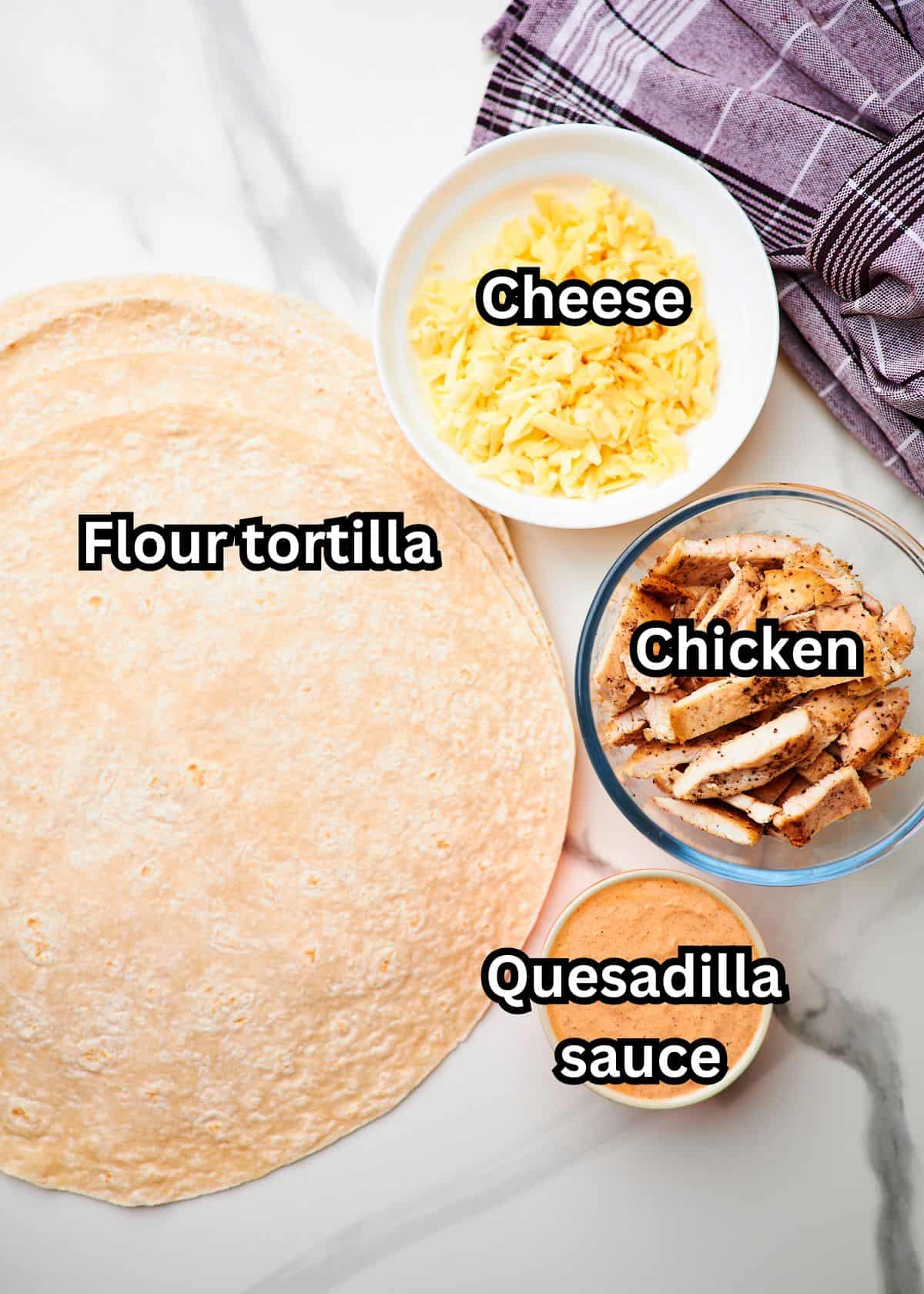 White marble counter top with bowls of ingredients to make chicken quesadillas.