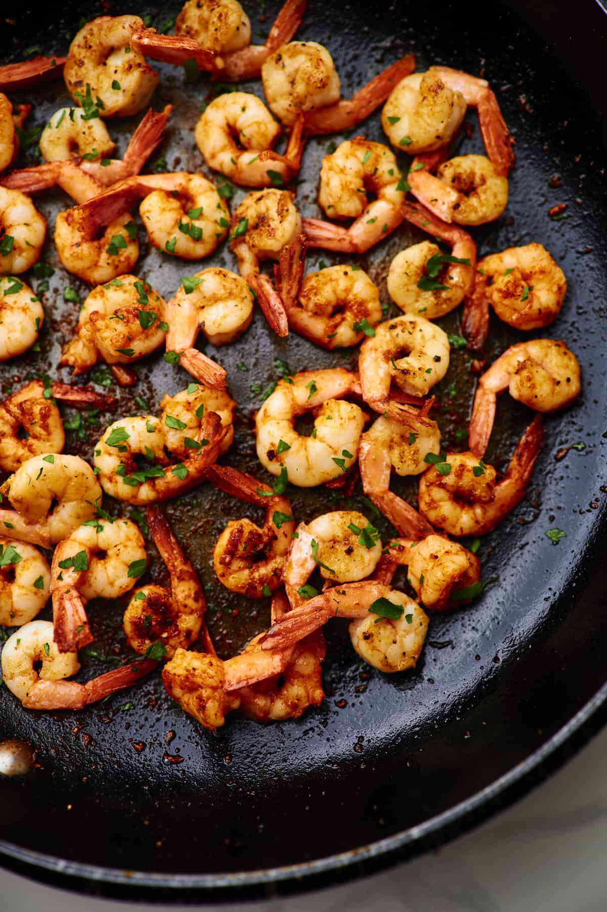 close up shot of garlic butter shrimp in a pan on the stove