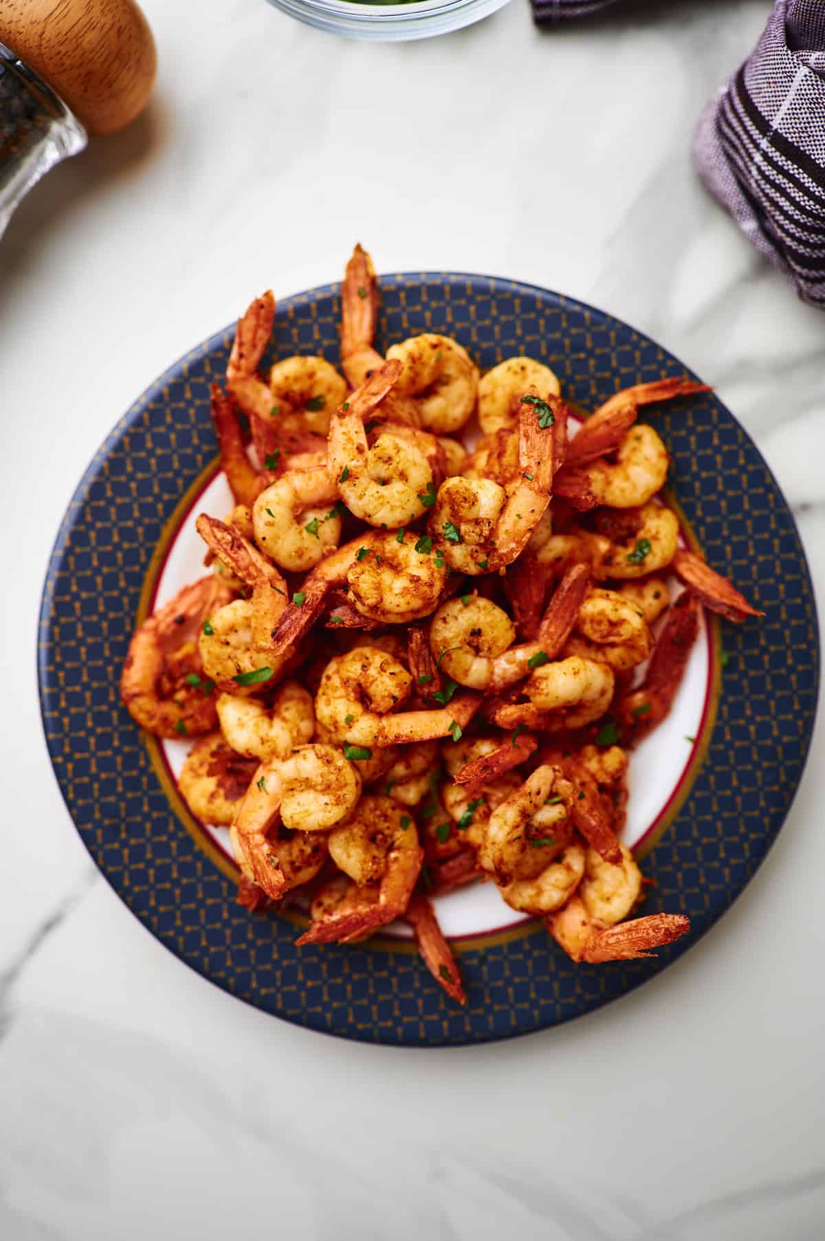 seared shrimp on a plate with fresh parsley on top