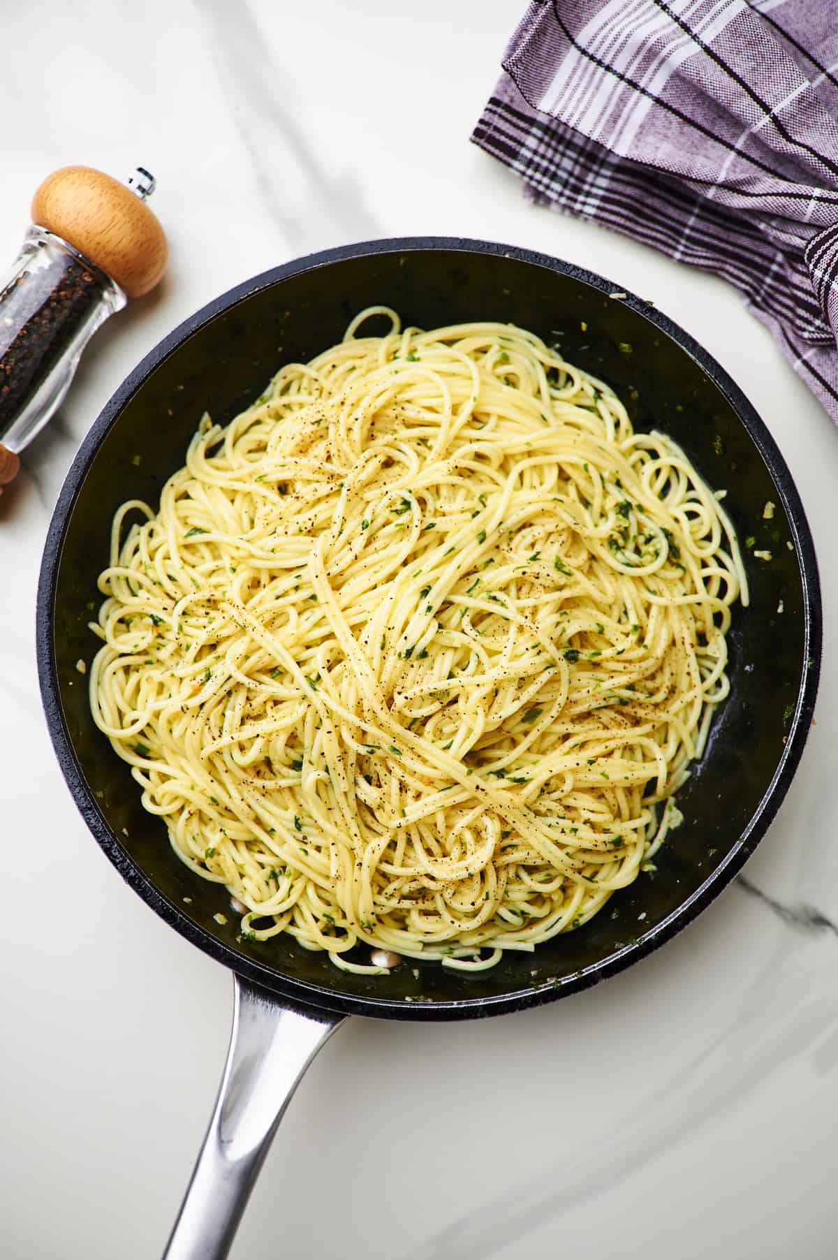 Large sauté pan filled with garlic butter sauced tossed with al dente linguine.
