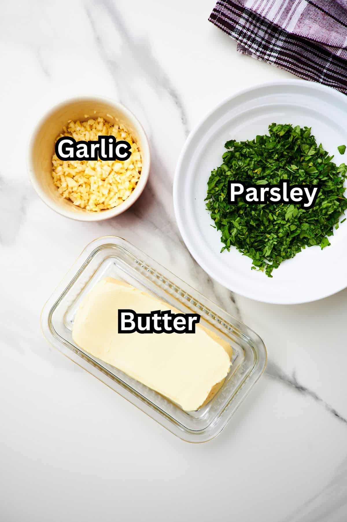 White counter top with bowls of ingredients to make garlic butter sauce.