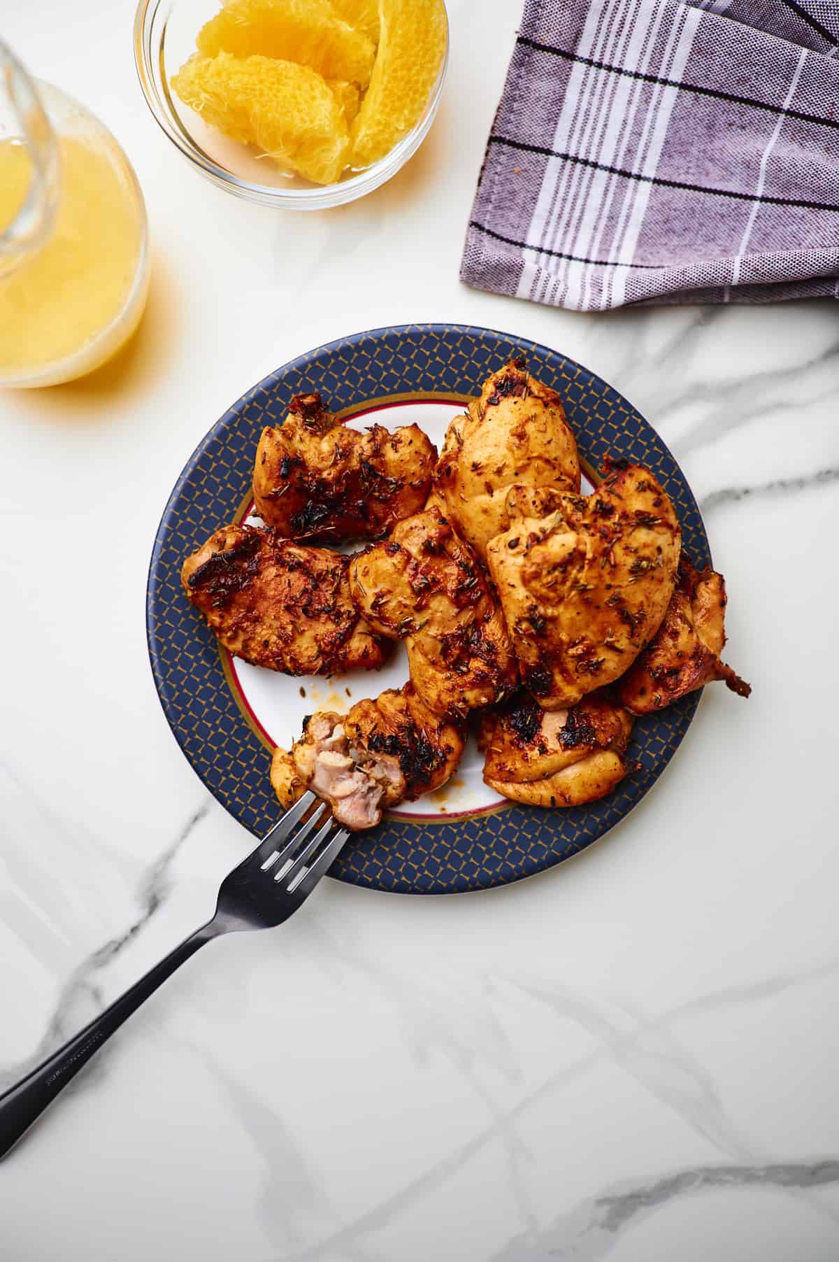 Close up of grilled boneless chicken thighs on a plate.