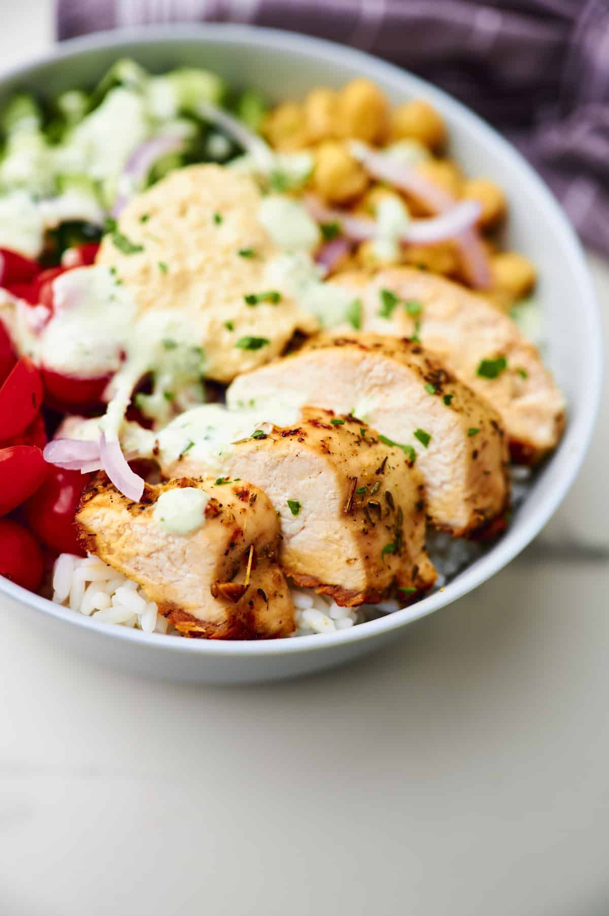 greek chicken and white rice bowl with fresh veggies 