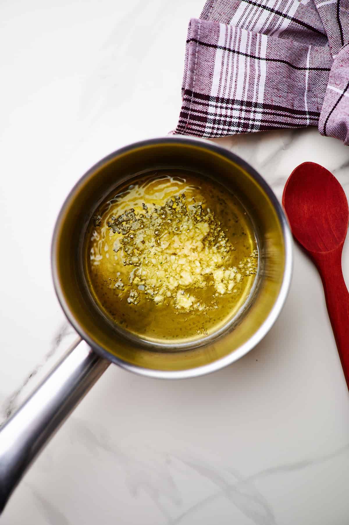 making garlic sauce in a small pan for tuna spaghetti