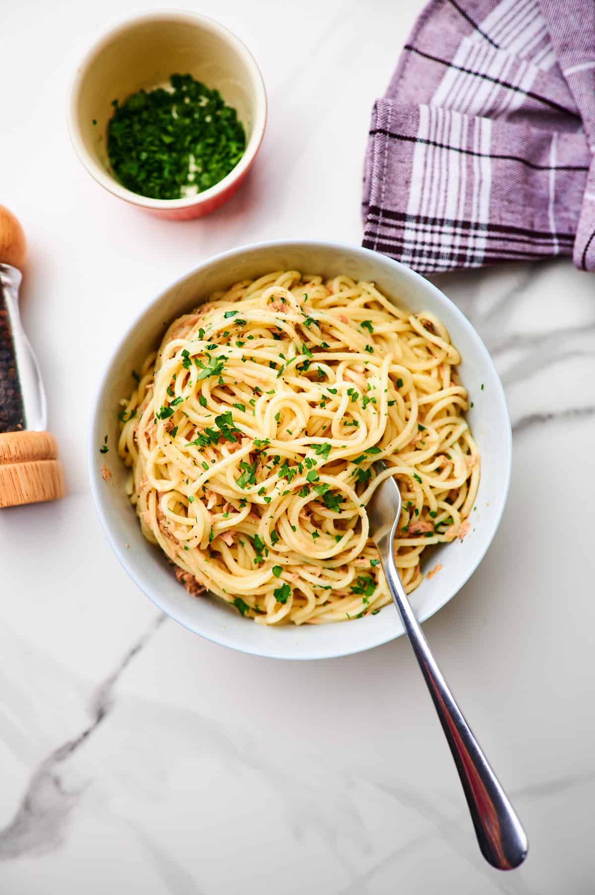 healthy 15 minute garlic tuna pasta in a bowl with spaghetti twirled on a fork