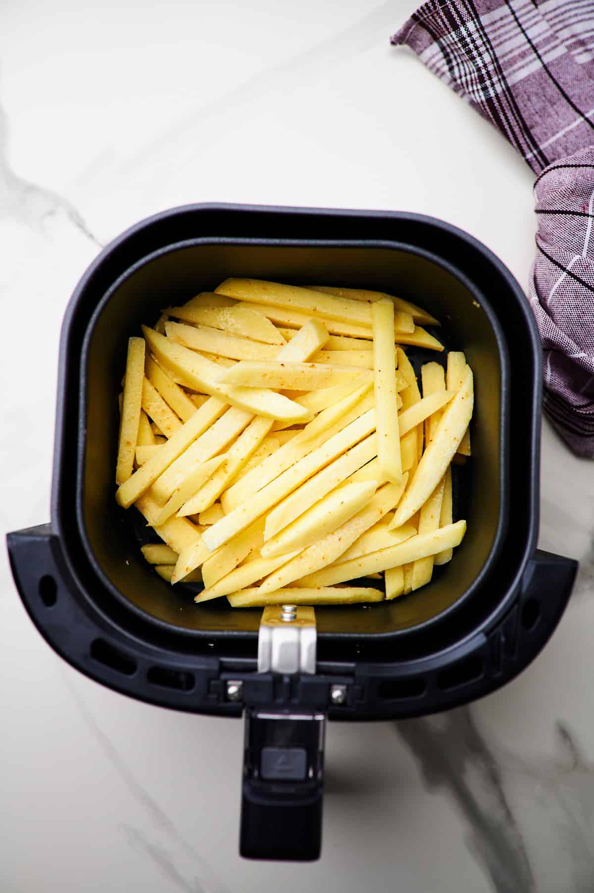 frozen french fries in air fryer basket.