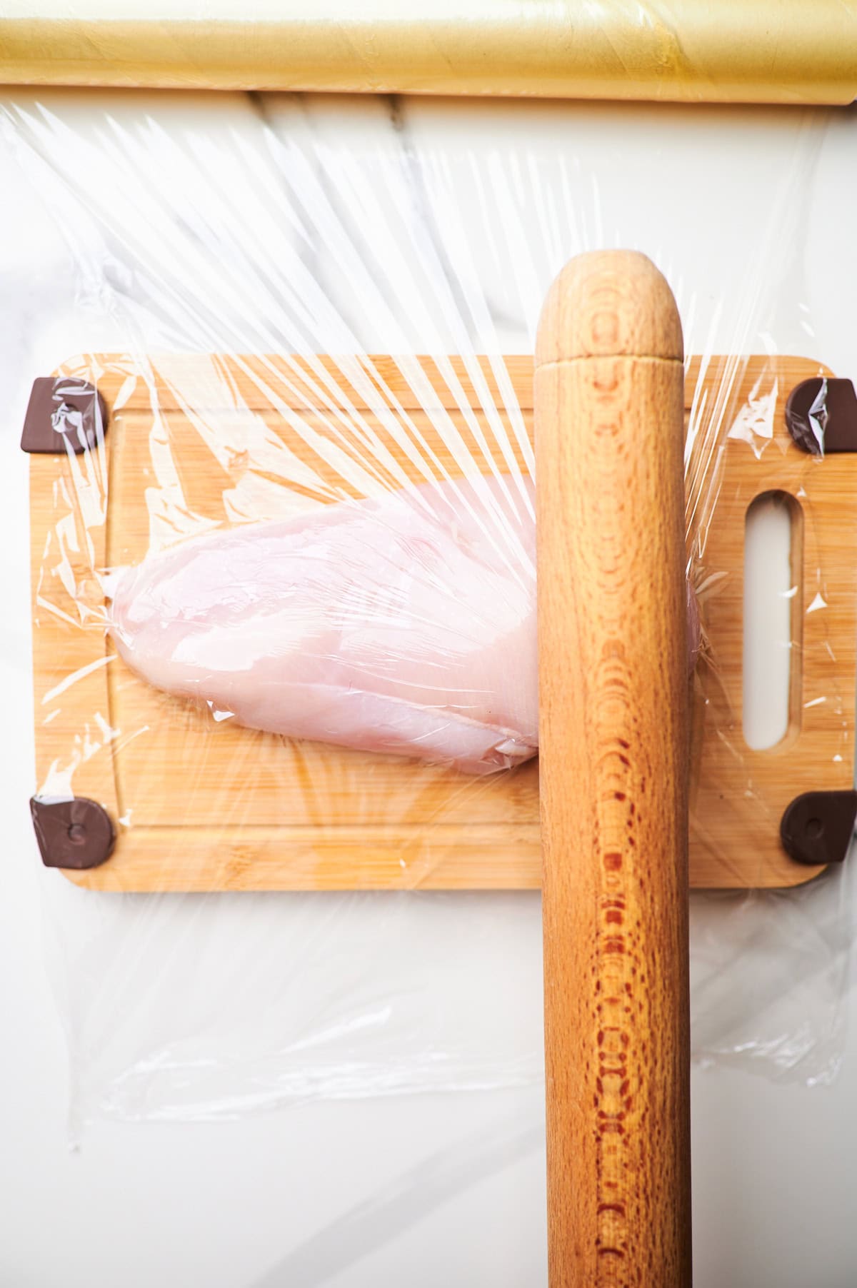 pounding chicken breasts with a roller pin.
