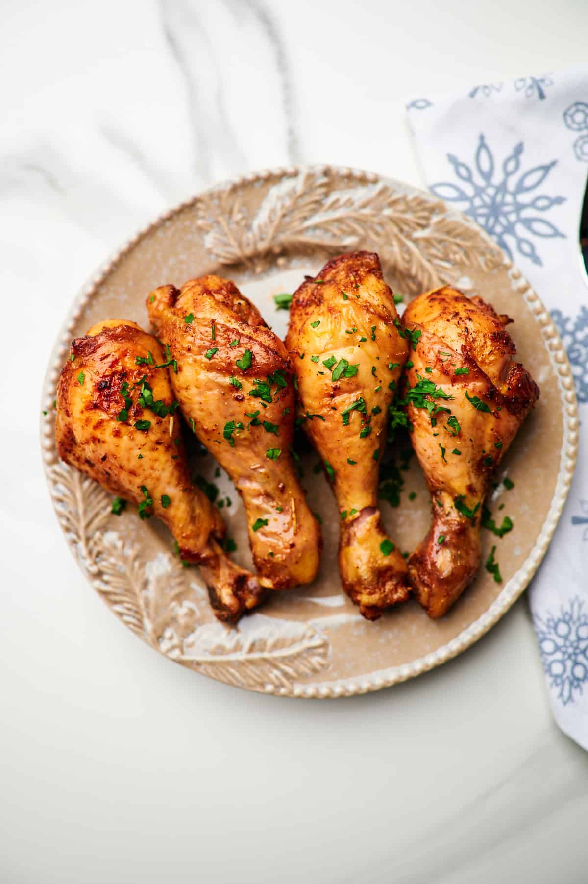 Overhead view of baked chicken legs in a dish.