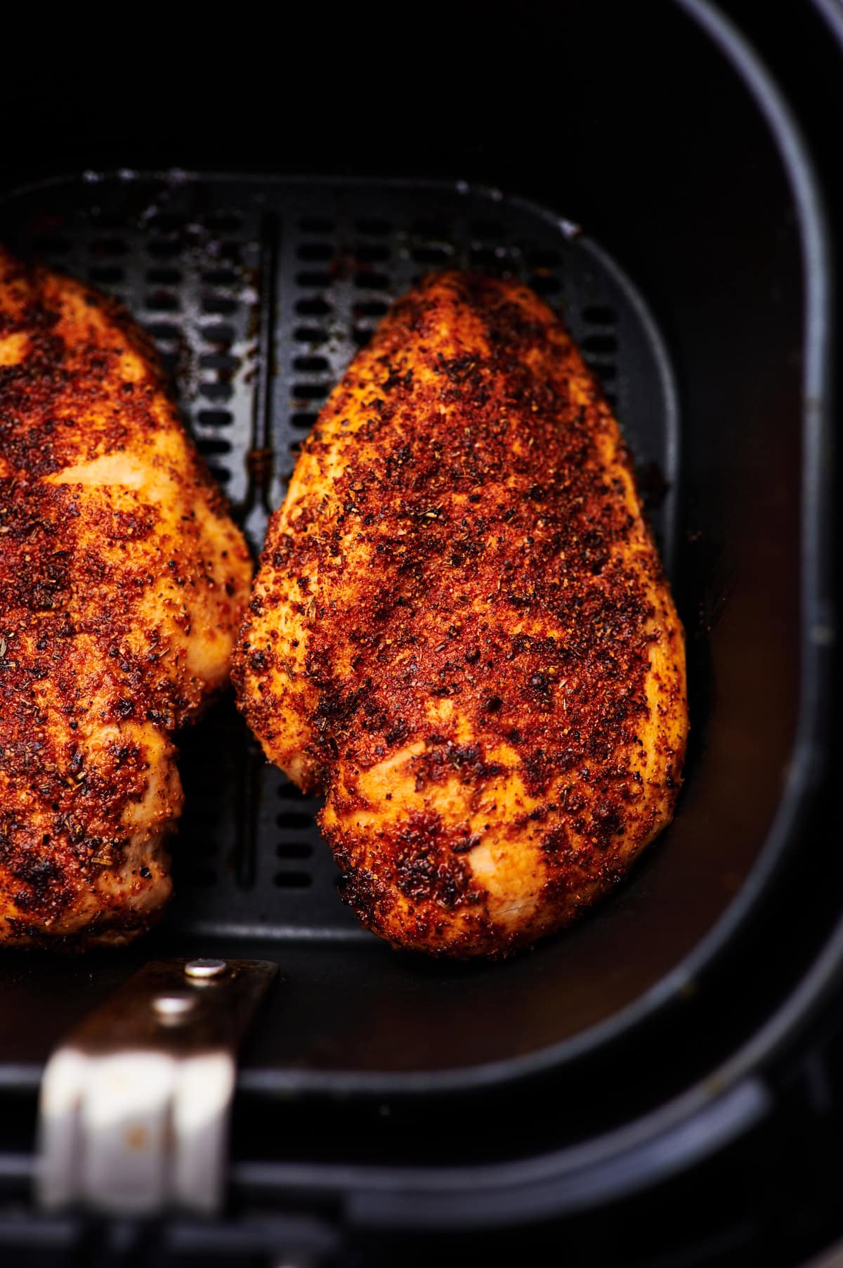 Chicken breasts in the air fryer basket.