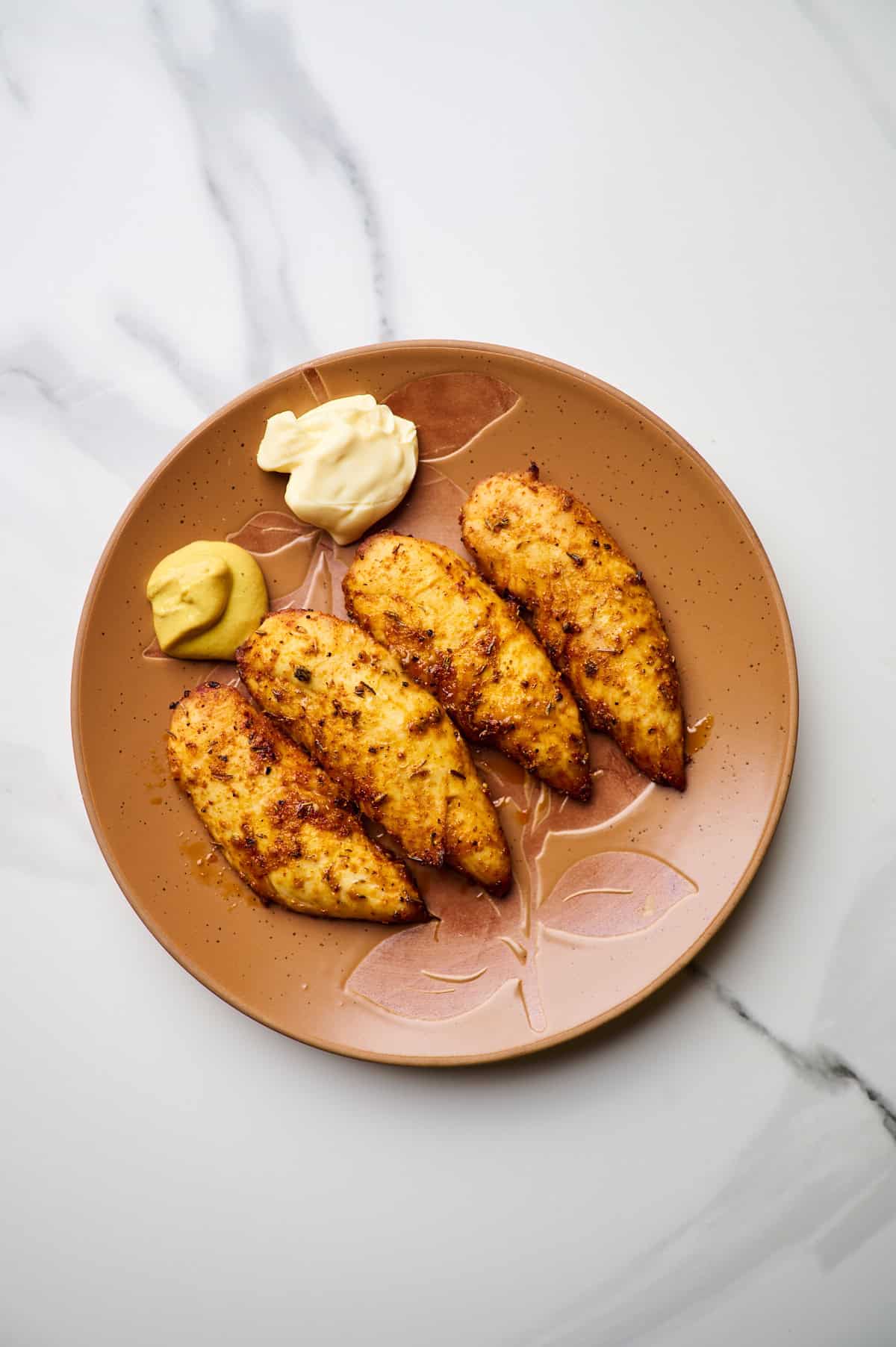 Air fryer chicken tenderloins served with mayo and dijon mustard on a brown plate